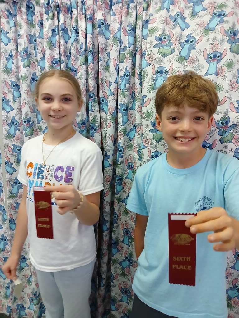 students displaying ribbons won at Science olympiad competition