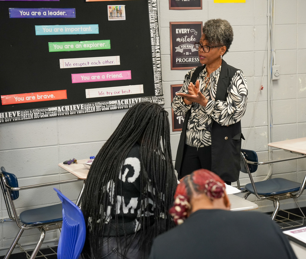 A woman speaks to a classroom of students.
