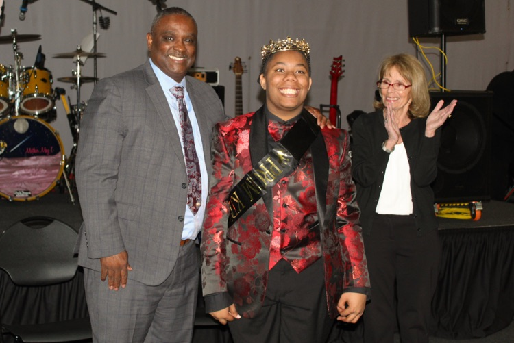 JEFCOED Superintendent Dr. Walter Gonsoulin poses for a photo with this year’s Exceptional Prom king. The prom king wears a red and black suit and a crown and sash.