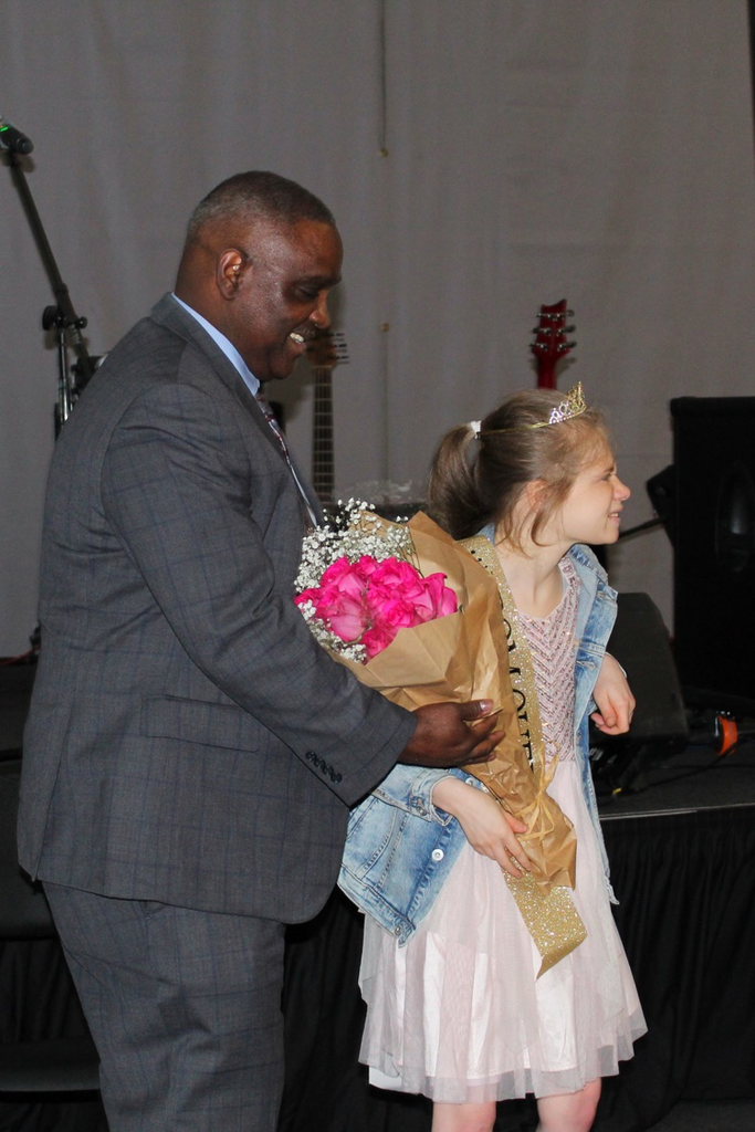 JEFCOED Superintendent Dr. Walter Gonsoulin hands flowers to this year’s Exceptional Prom queen. The student wears a pink dress and Jean jacket and a crown.