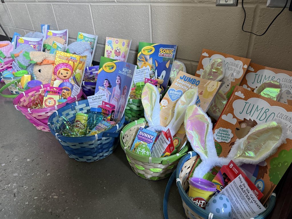 Baskets filled with toys and activities sit on the floor of a room.
