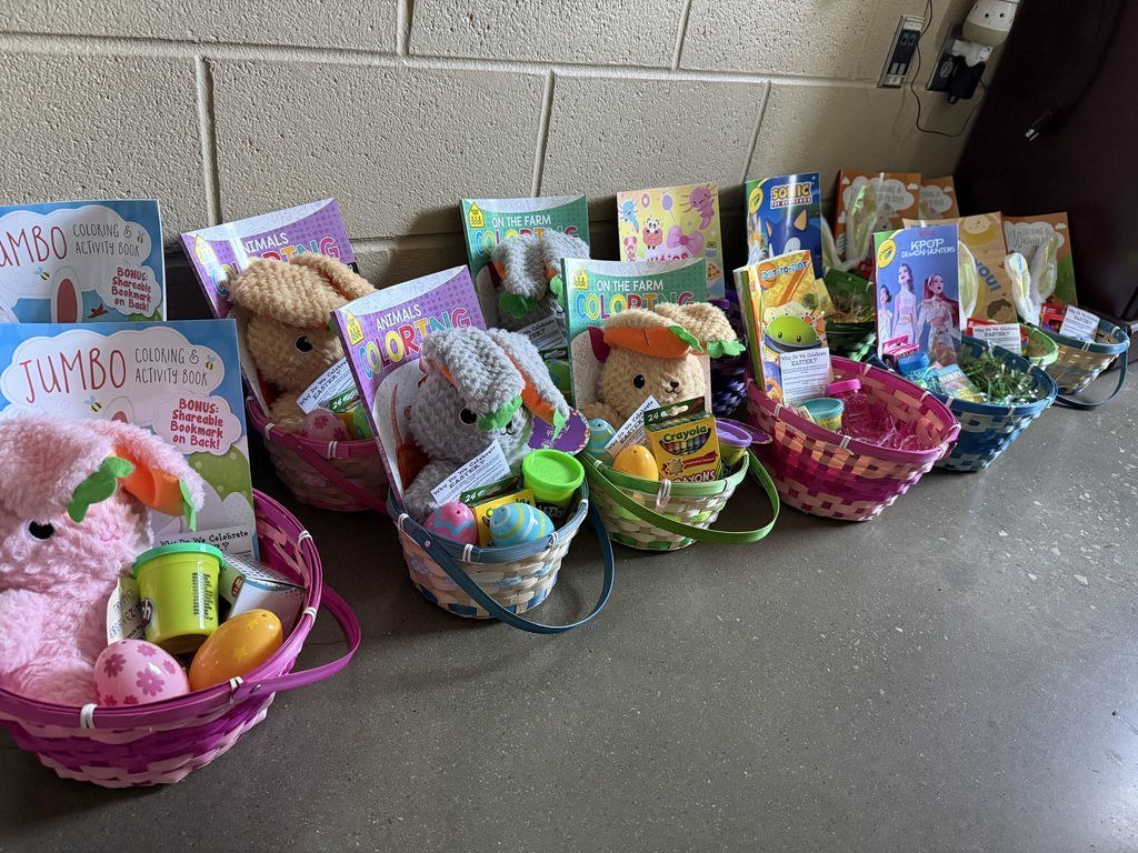 Baskets with toys and activities for children sit on the floor of a room.