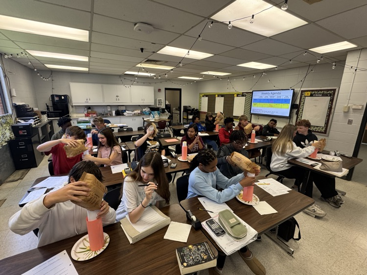 students putting popcorn into cylinders as part of a math lab.