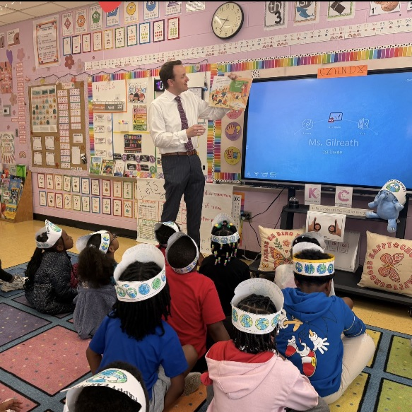 A picture of the weatherman Jonathan Hardison reading a book about earth day to Ms. Gilreath's class.
