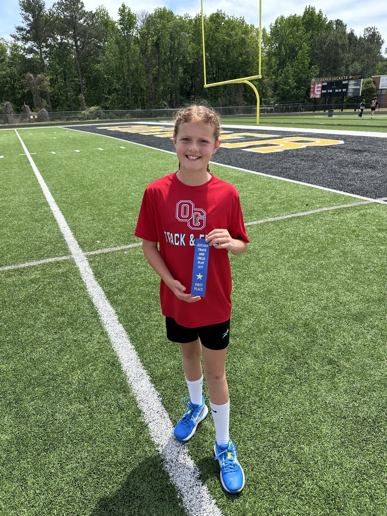 Oak Grove female middle school student holding a first place ribbon for track