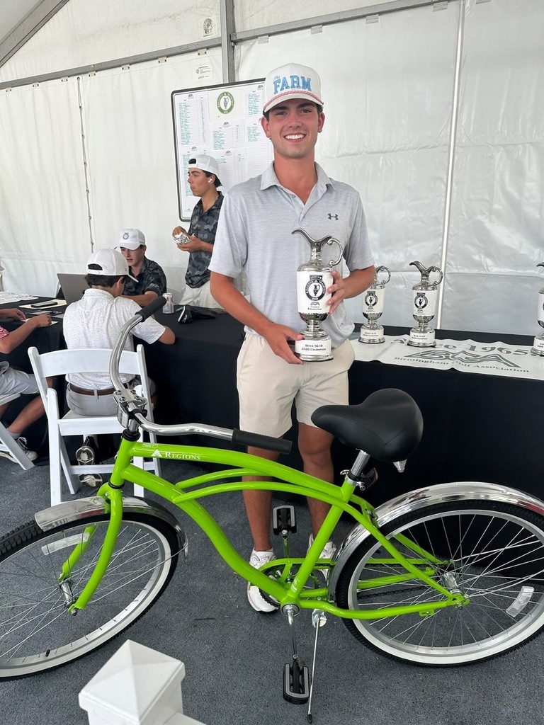 Michael Collins poses with his Junior Regions Tradition Trophy and a green Regions Bicycle after winning the golf tournament.