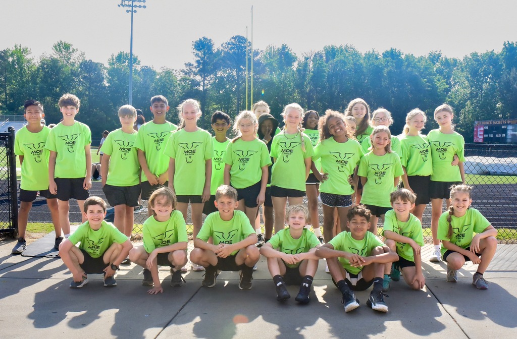 students at at a track meet posing as a group  