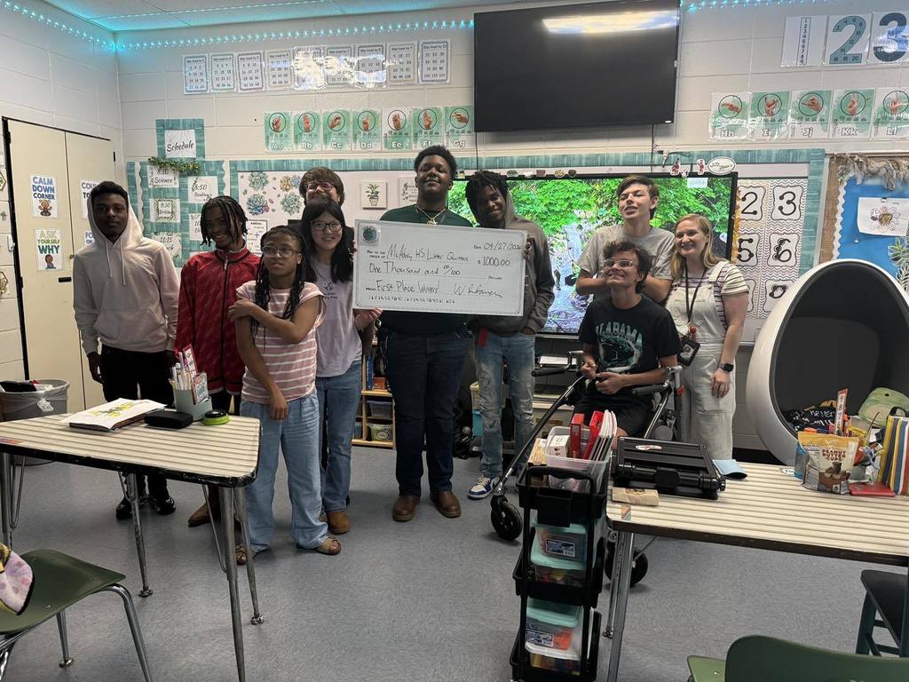Ms. Vining's students at McAdory High School stand together for a photo. One of the students holds a big check from their award-winning Litter Quitters video project.