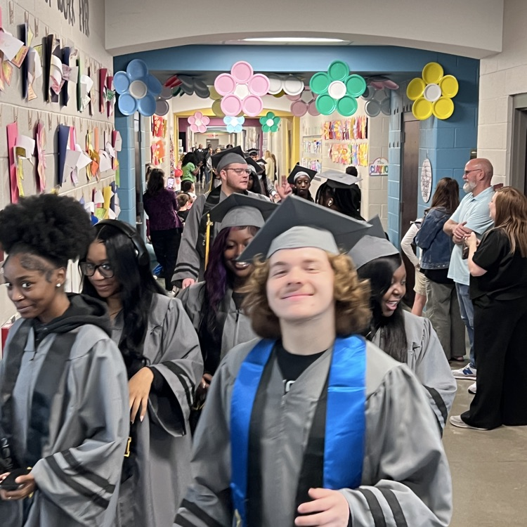 High school seniors in the caps and gowns walking the halls of McCalla Elementary