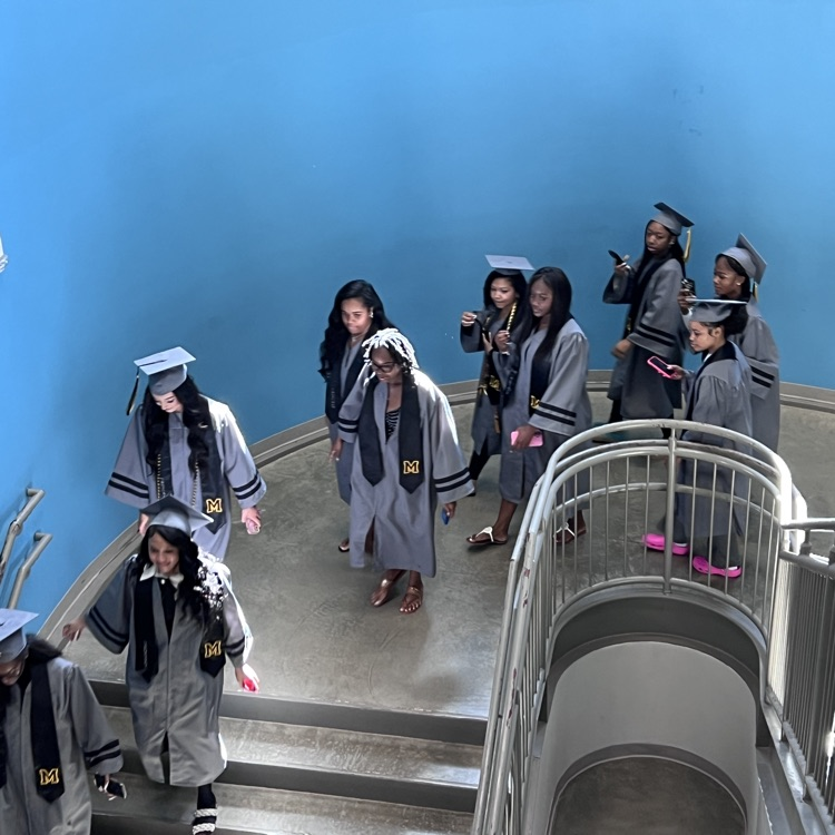 High school seniors in the caps and gowns walking the halls of McCalla Elementary