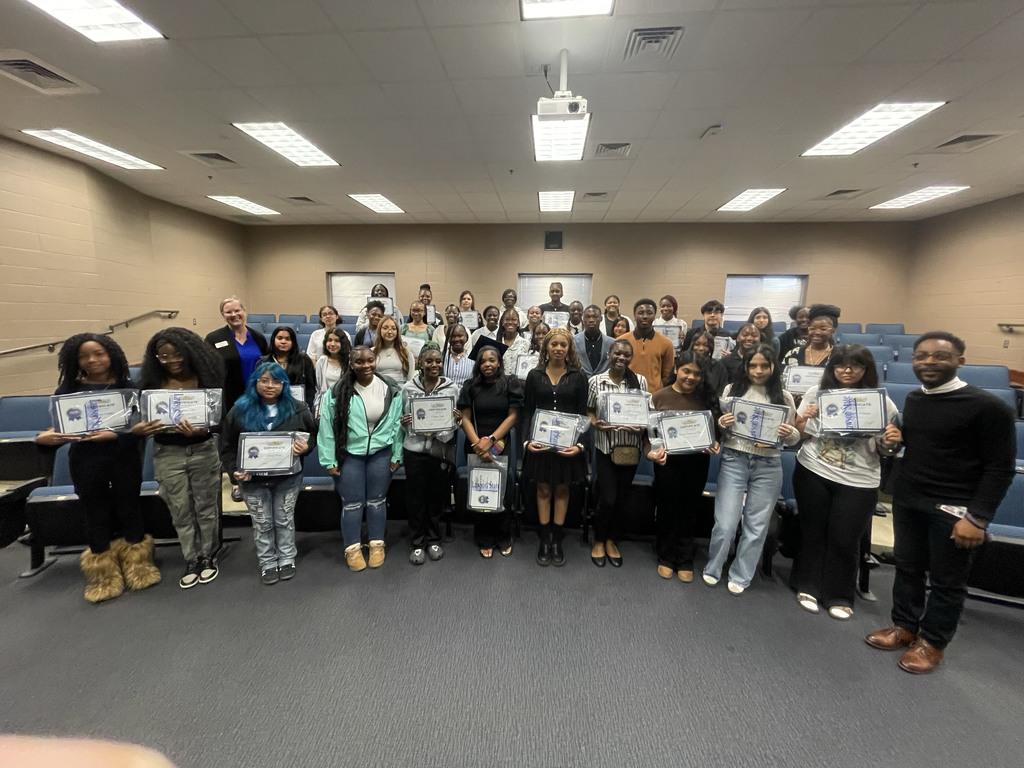 Students in the JEFCOED ACE program stand together for a photo inside a room. They hold award certificates in their hands.