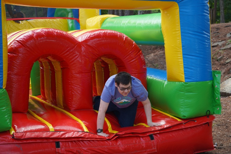 A boy climbs through an inflatable.