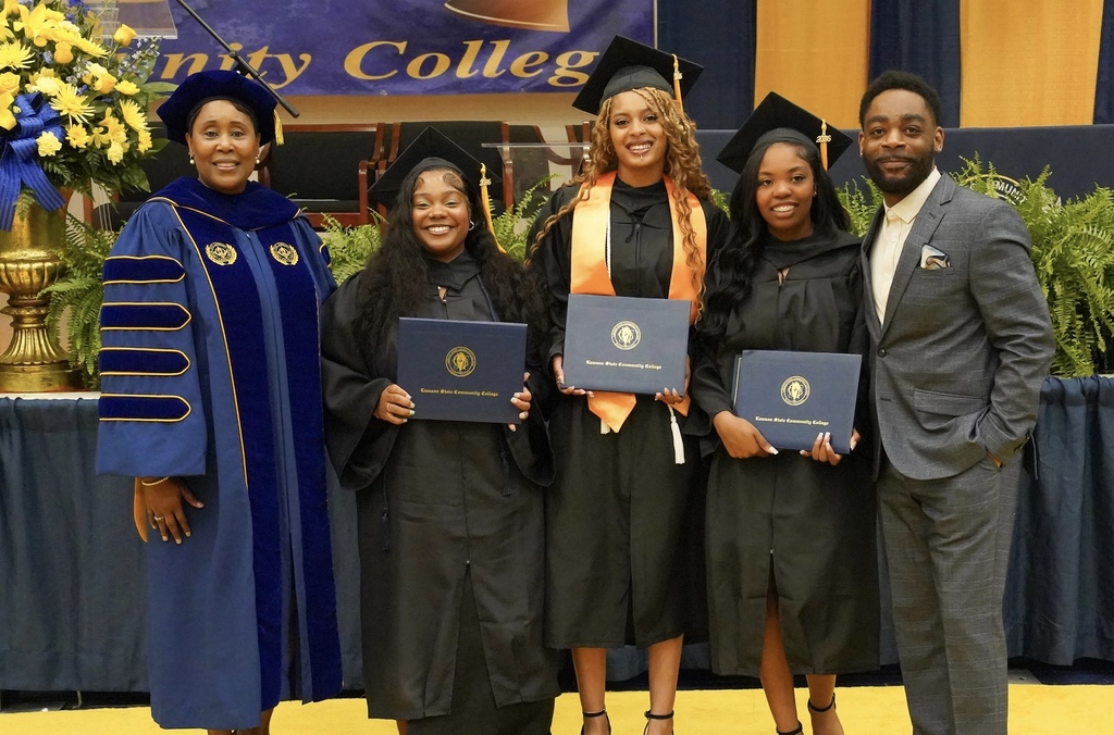 JEFCOED dual enrollment graduates stand together for a photo with the president of Lawson State Community College and a School Counselor for the Academy of College Excellence.They all wear graduation robes and caps.