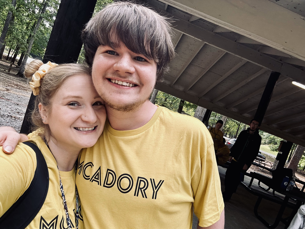 Joseph Hamrick and his teacher, Ms. Vining smile for a photo. They wear matching yellow McAdory t-shirts.