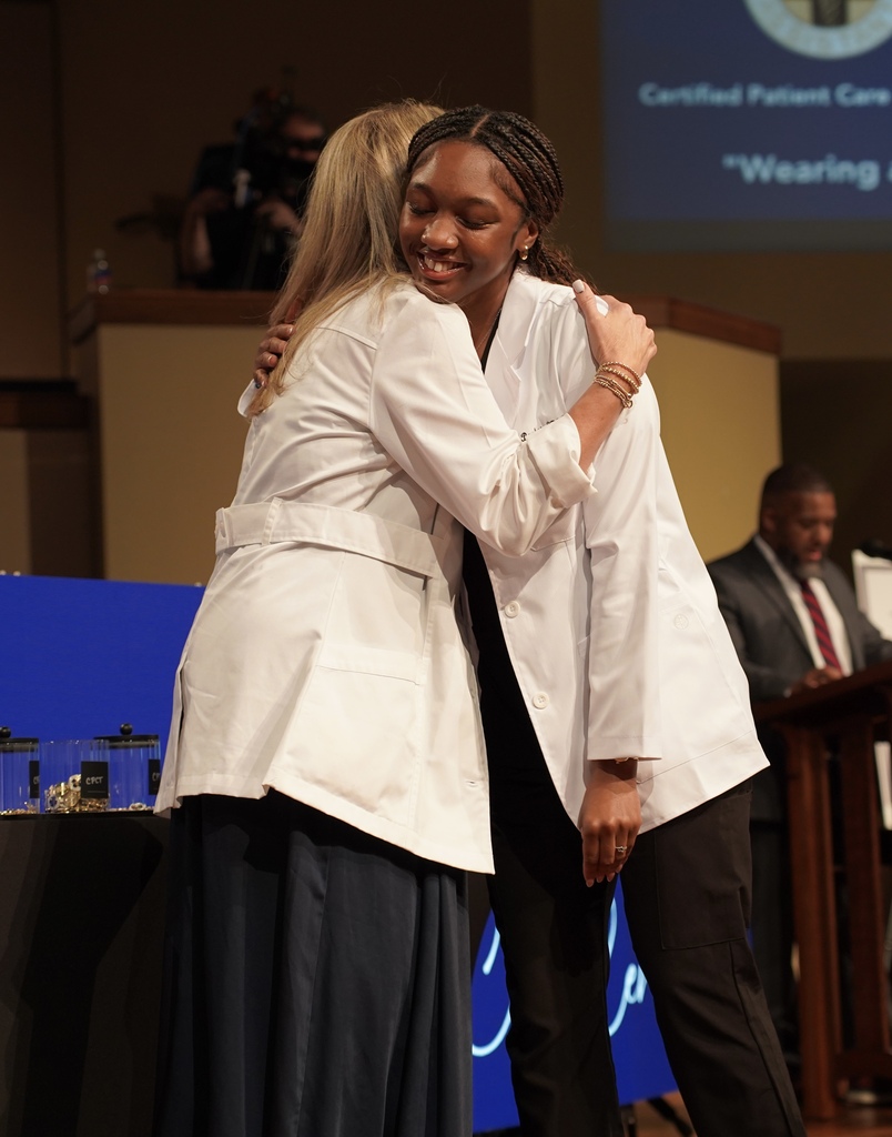 A girl hugs a woman during the JEFCOED White Coat Ceremony.