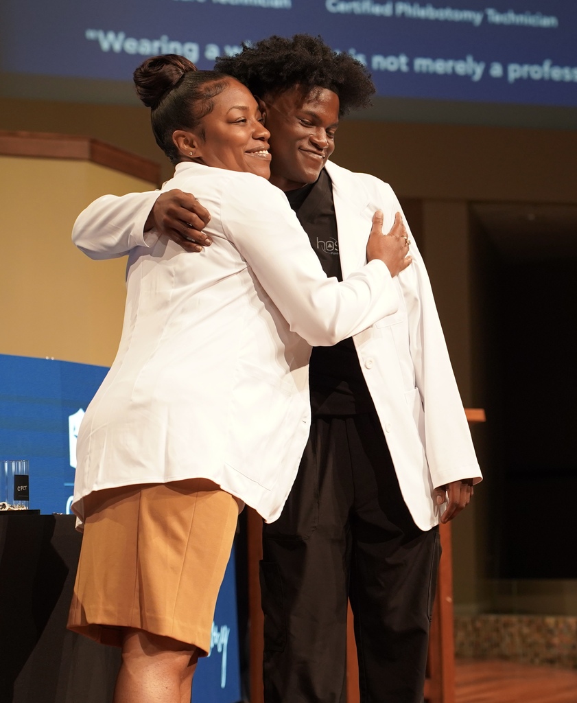 A woman hugs a student during the JEFCOED White Coat Ceremony.