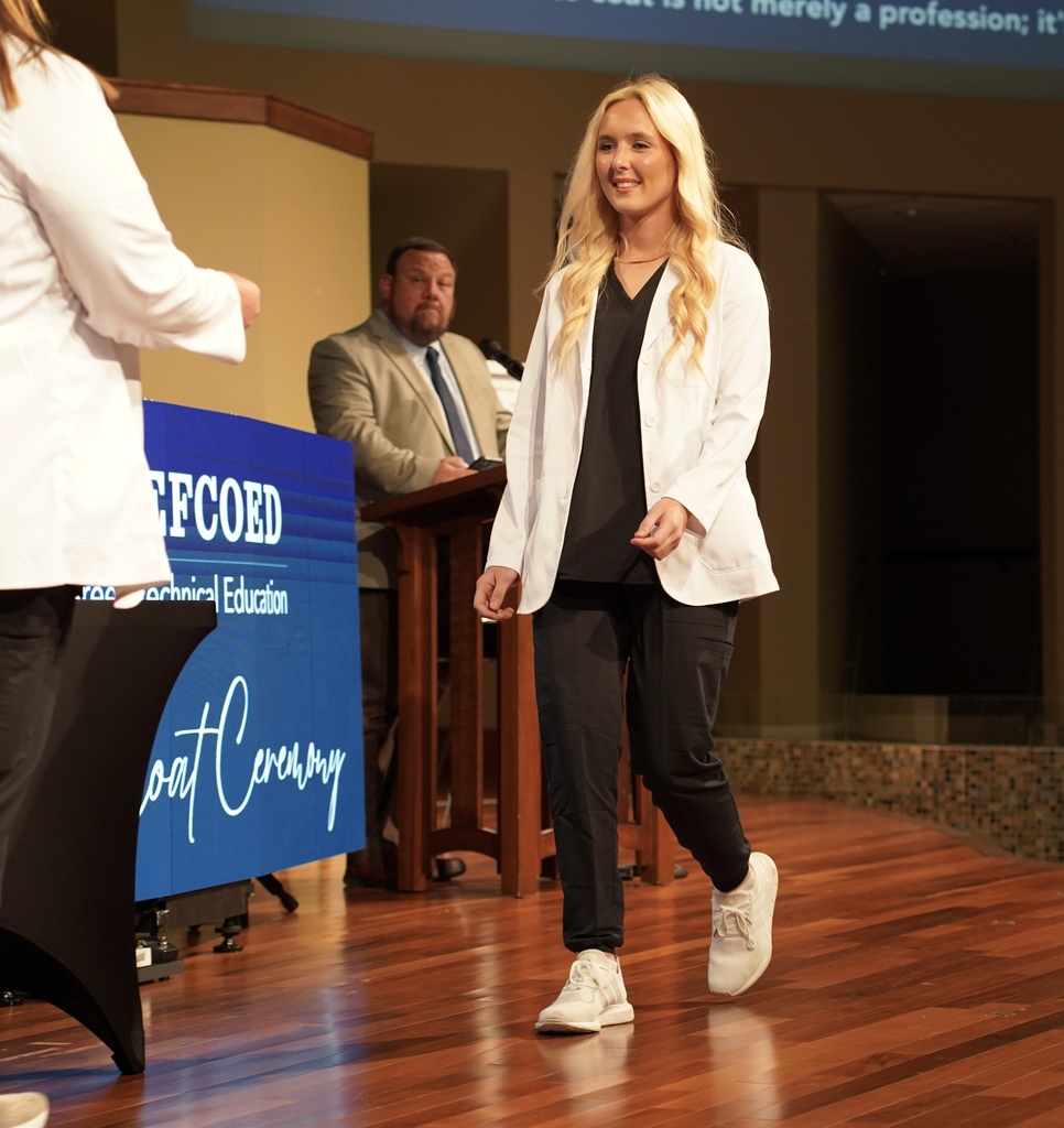 A girl walks across the stage during the JEFCOED White Coat Ceremony.