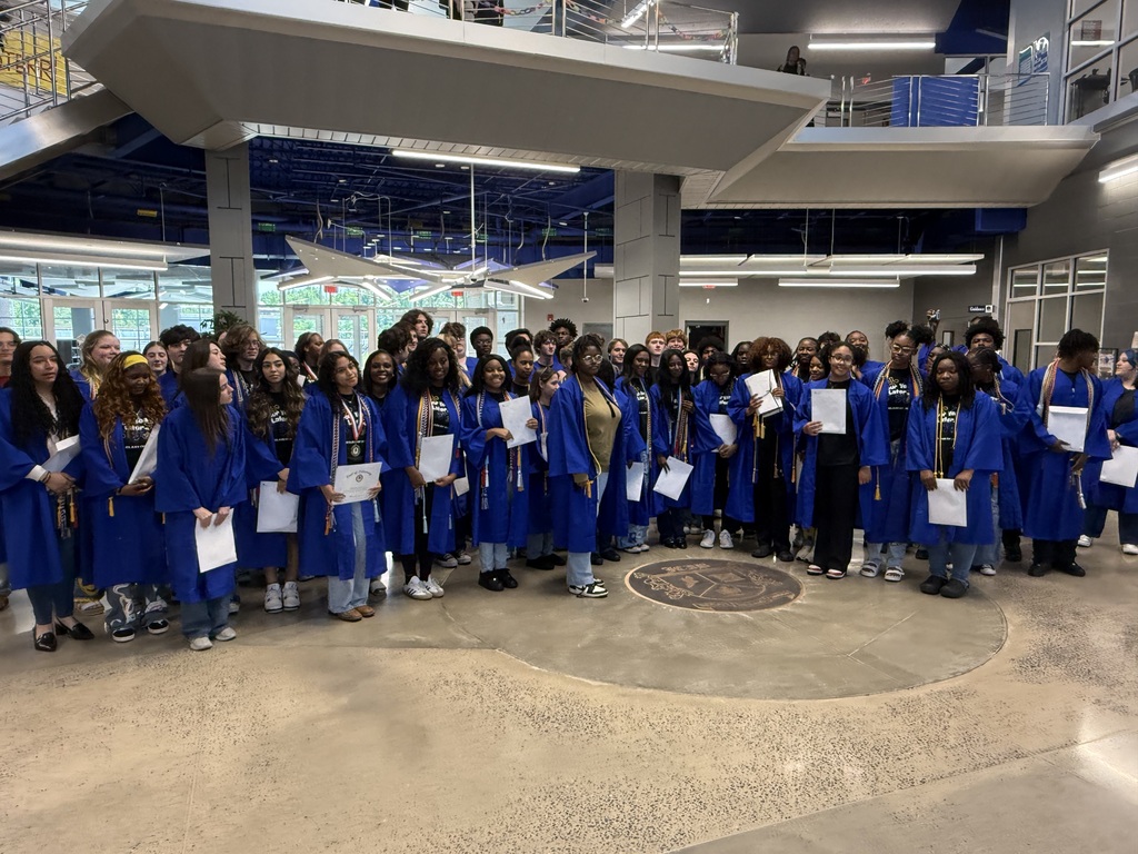 graduates pose for a group pic in their robes after being presented them