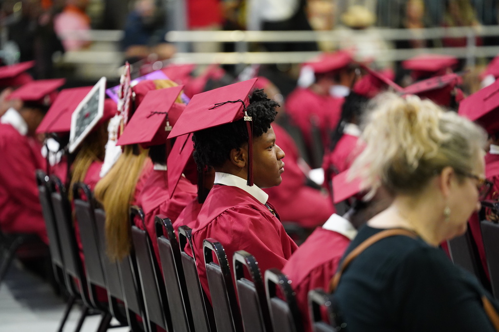 Students wearing caps and gowns sit in chairs during the Shades Valley High School graduation ceremony.