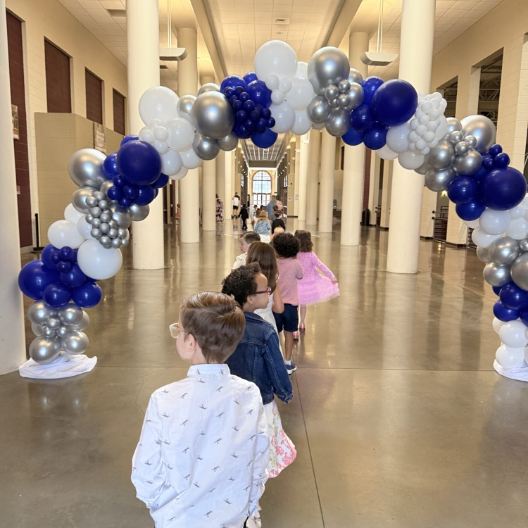 kids walking under balloon arch 