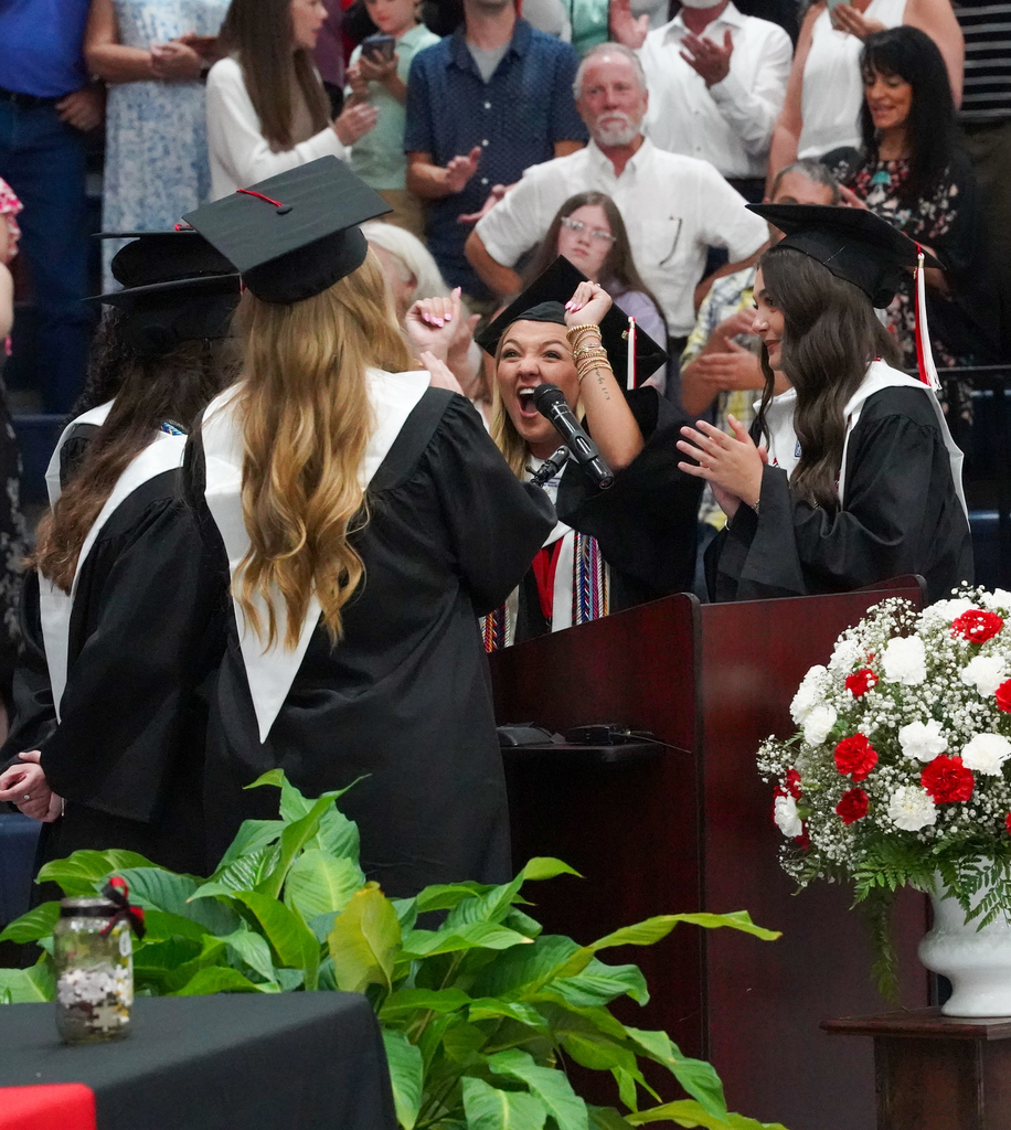 Graduates cheer after singing the alma mater into the microphone during Oak Grove's graduation ceremony.