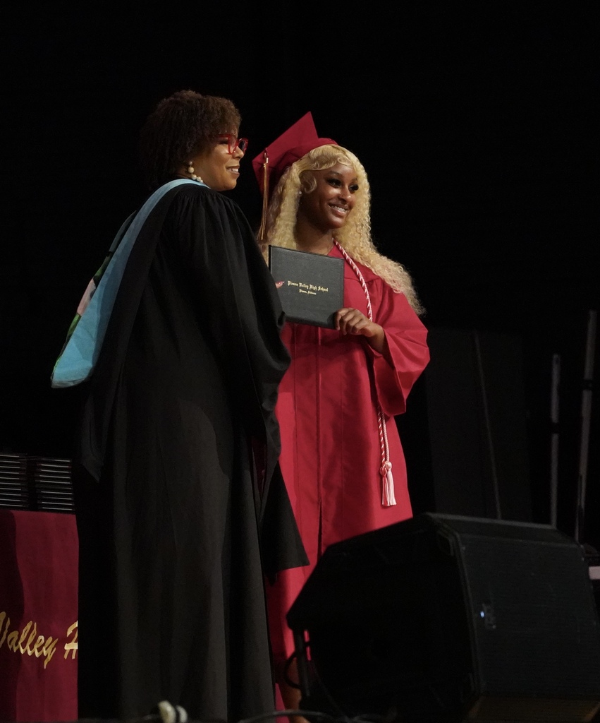 A student smiles as she receives her high school diploma during the Pinson Valley High School graduation ceremony.