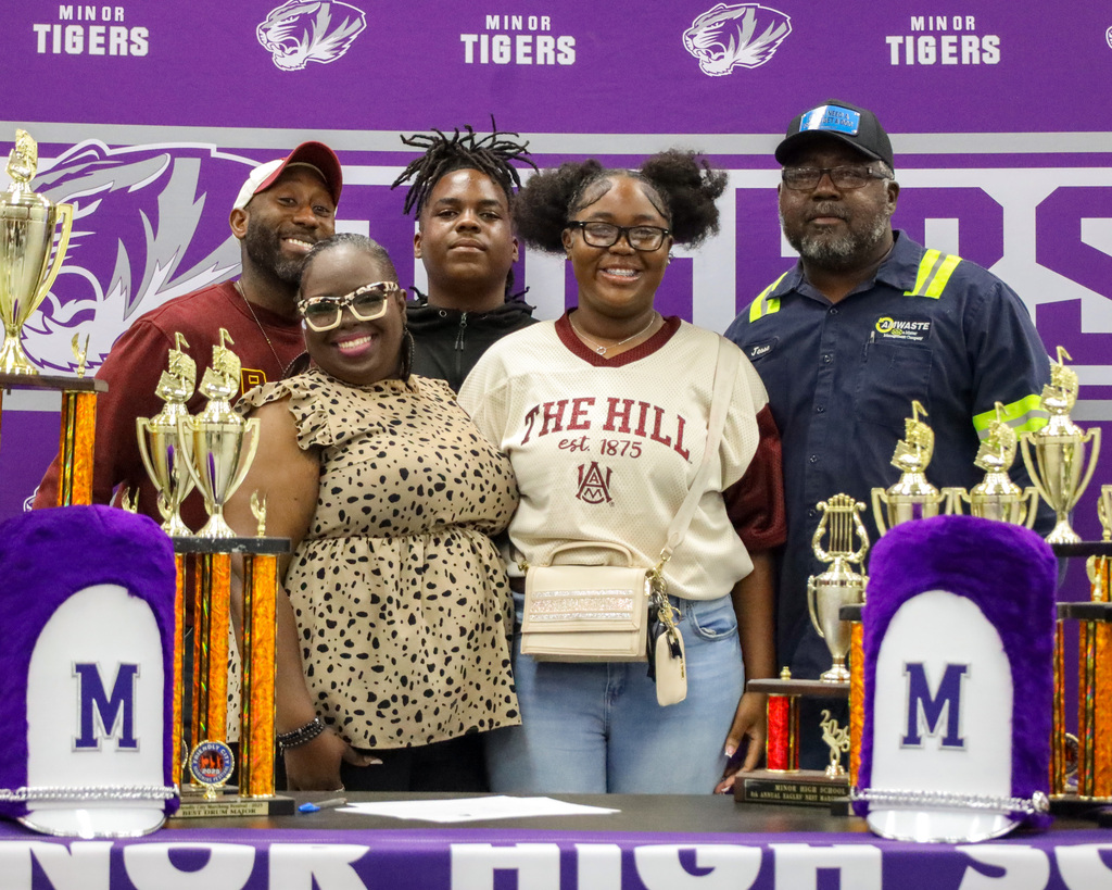 A Minor High School band students takes a picture with family, friends, and band director during 2025-2026 signing day. 