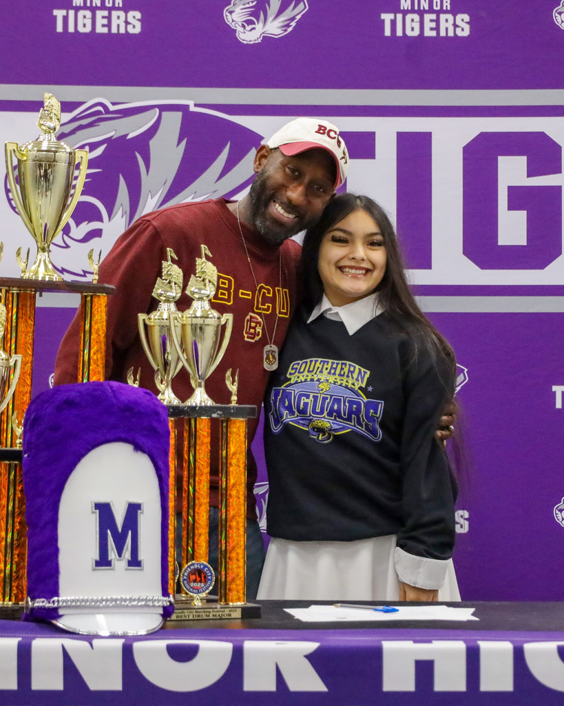 A band student student takes a picture  with her band director during signing day at Minor High School.