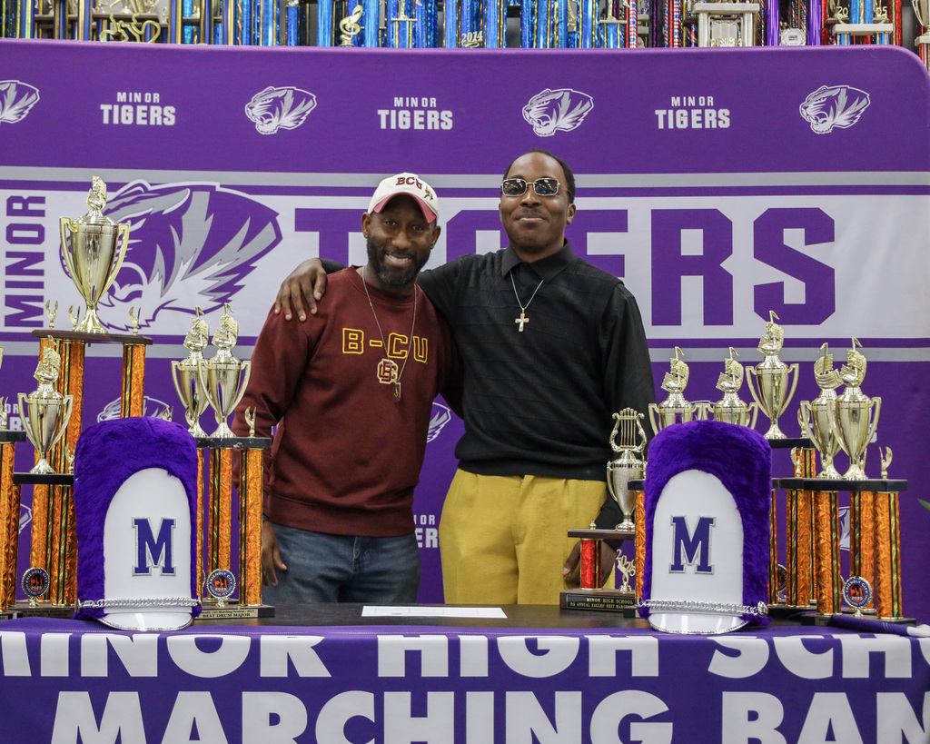 A Minor High School band student takes a picture with his band director during a signing day event.