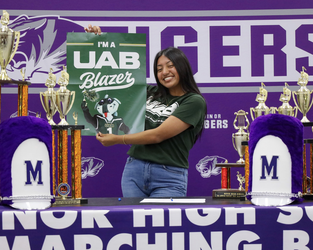 A Minor High School Band student holds up a UAB Blazer banner on signing day.