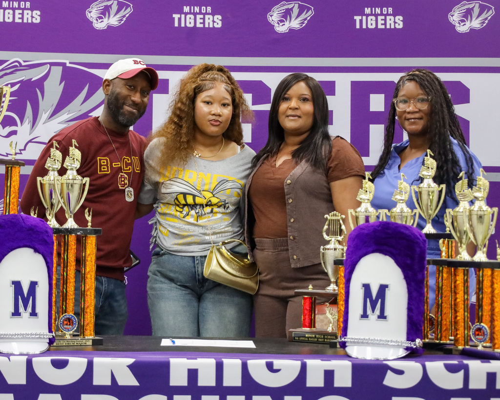 A band student student takes a picture  with friends and family during signing day at Minor High School.