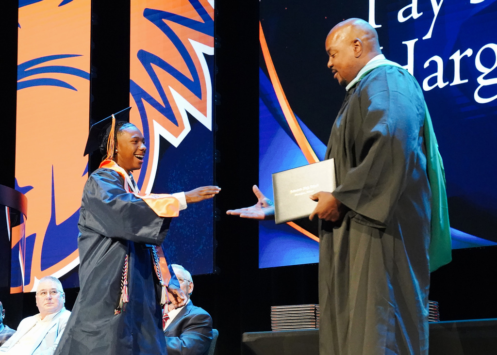 A graduate reaches out to shake hands with his school principal during the 2026 Fultondale High School Graduation.