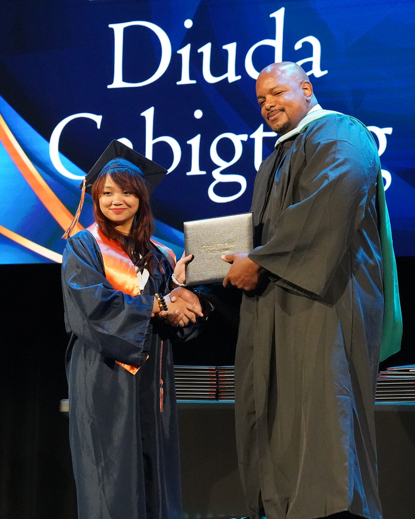 A high school senior receives her diploma from her principal during the 2026 Fultondale High School Graduation.