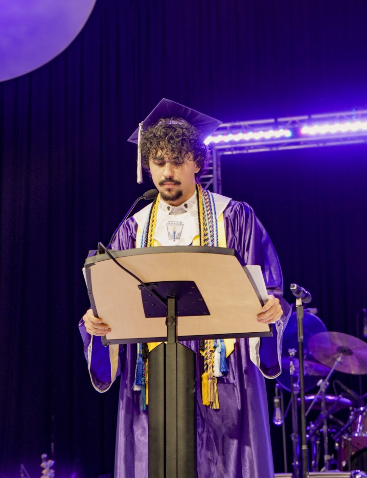 A Minor High School graduate speaks into a microphone at a podium during the high school’s graduation ceremony
