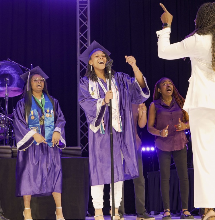 Students sing on stage during the Minor High School graduation ceremony