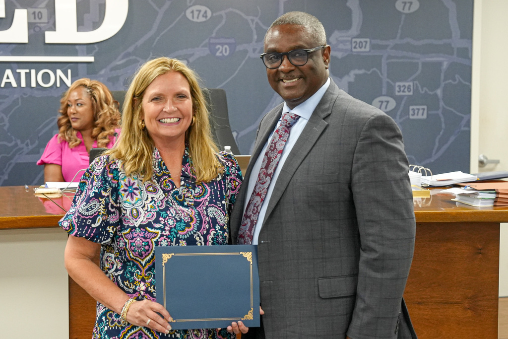 Kristi Long and Superintendent Dr. Walter Gonsoulin smile for a photo inside the JEFCOED board room.