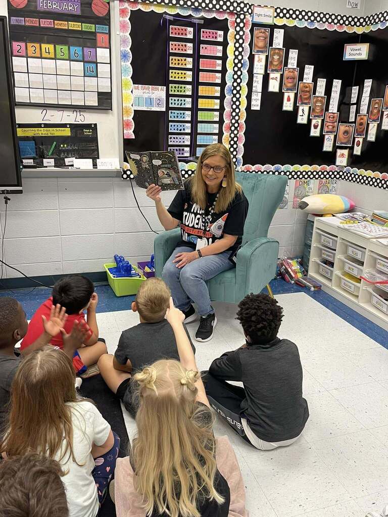 Snow Rogers principal Kristi Long reads a book to a group of students.