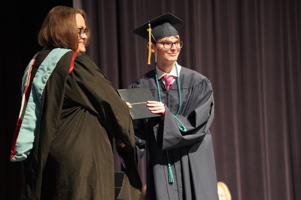 A JCVAL graduate smiles for a photo with the school's principal after receiving his diploma during the school's graduation ceremony.