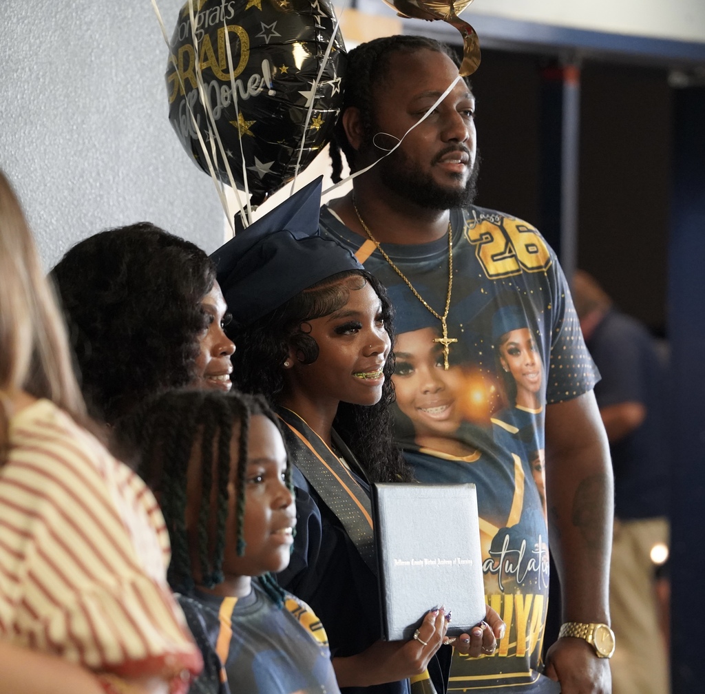 A JCVAL graduate poses for a photo with loved ones following the school's graduation ceremony.