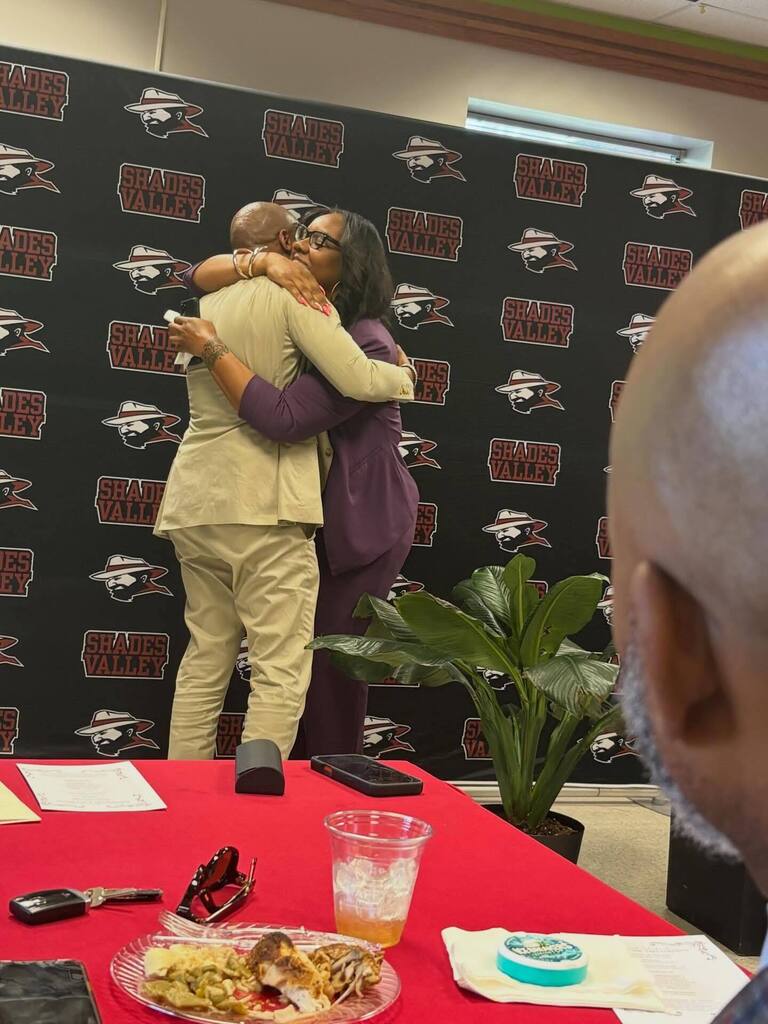 Shades Valley Principal Taki Sarhaan hugs a woman during his retirement party.