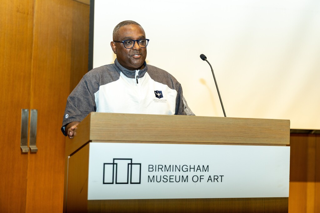 Superintendent Dr. Walter Gonsoulin speaks into a microphone on a podium at the Birmingham Museum of Art.