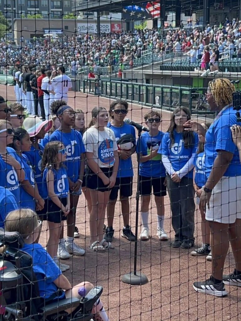 Concord Elementary School's choir sings into a microphone during a Barons game at Regions Field.