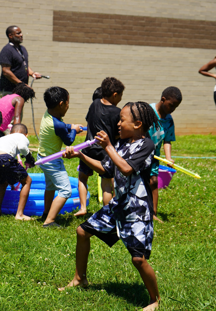 Students play with water guns outside a school.