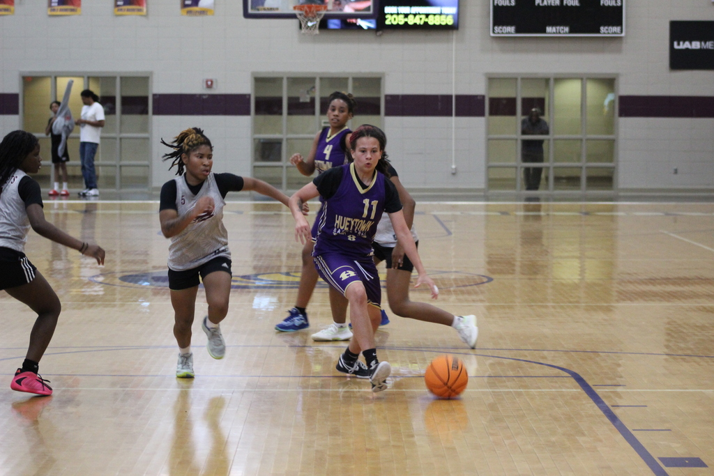 A Hueytown High School basketball player dribbles the ball down the court.