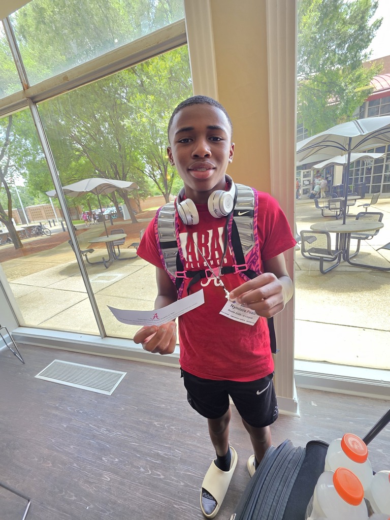 Bragg Middle School student Nymiere Peals smiles for a photo while attending the University of Alabama's overnight basketball camp. He wears a University of Alabama shirt.