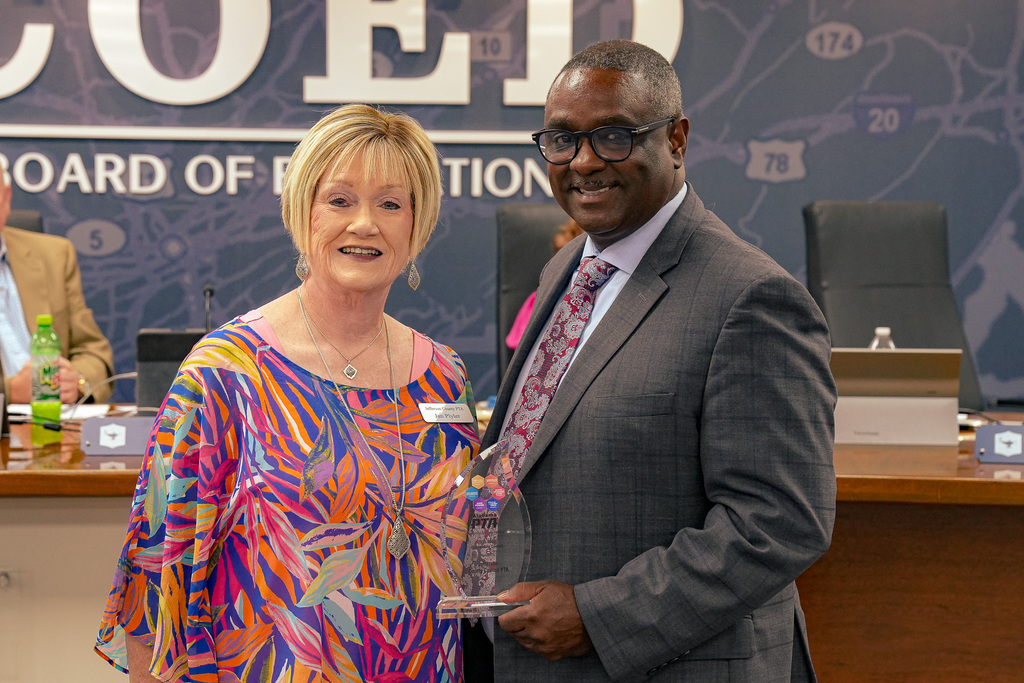 Superintendent Dr. Walter Gonsoulin poses for a photo with Jan Plyler in the Jefferson County Schools board room.