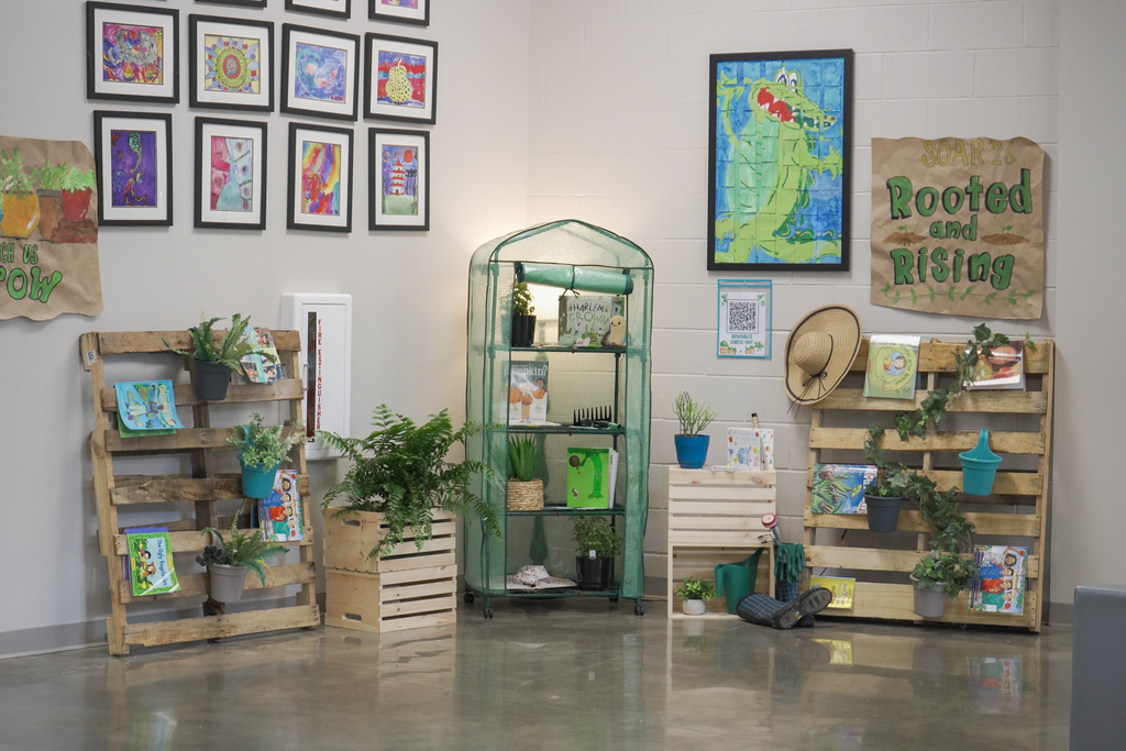 A room in a school decorated with art, books and plants.