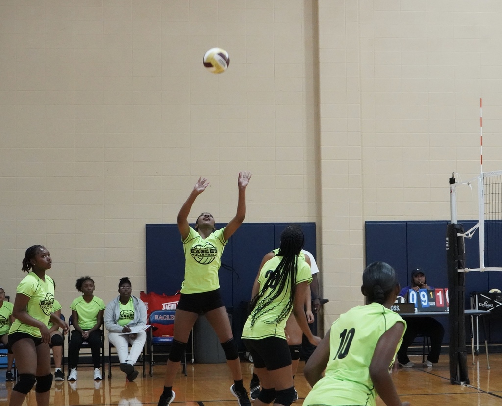 A Center Point High School volleyball player sets the ball during a game inside a school gym.