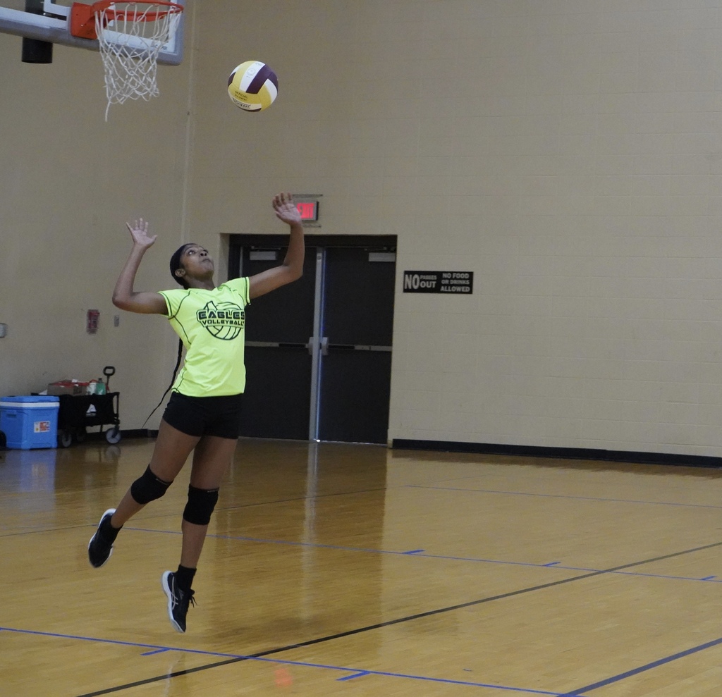 A Center Point High School volleyball player serves the ball during a game.