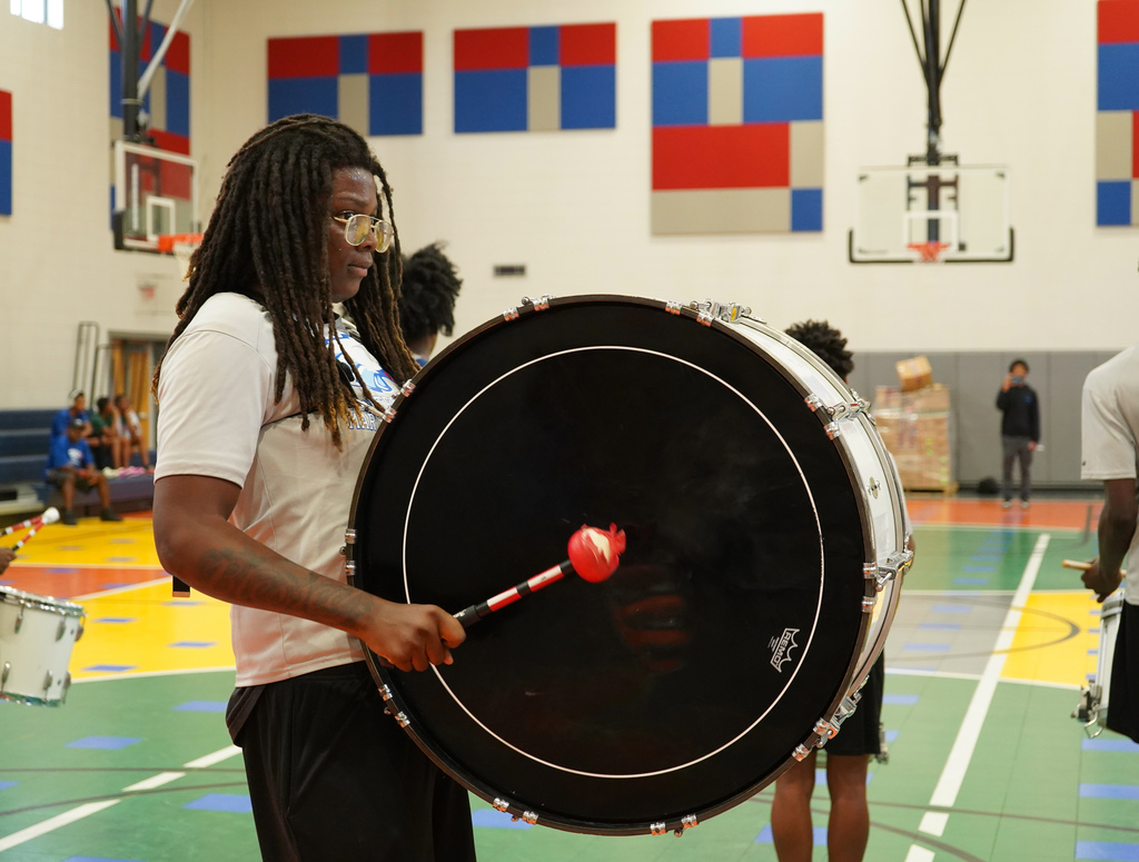 A Center Point High School student plays the drums during a performance in a school gym.